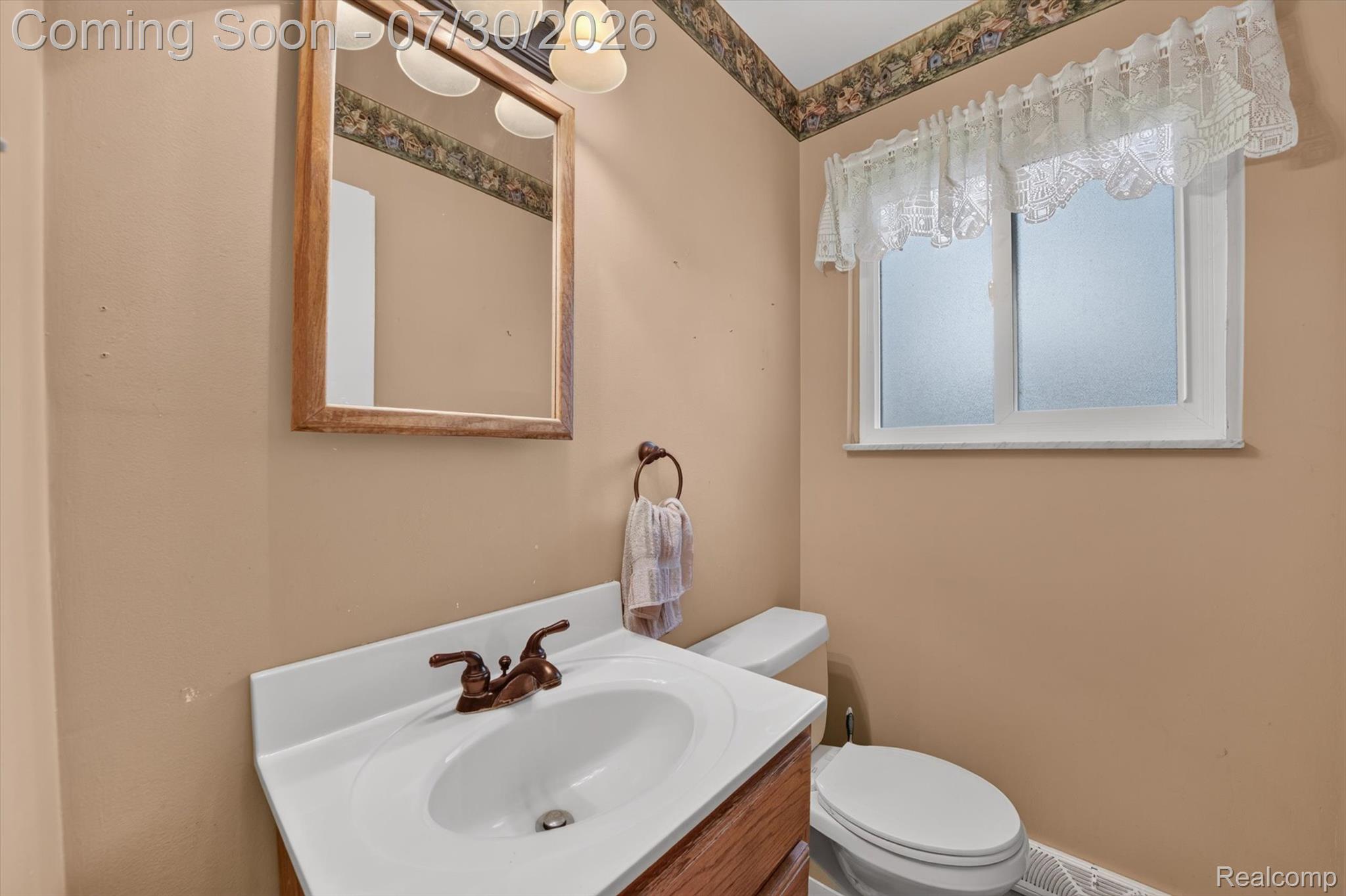 5991 Maybee Road Clarkston, MI 48346 - Photo 22 of 41 Bathroom vanity with integrated sink, bronze-finish faucet, and coordinating mirror