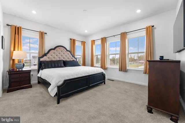 a spacious bedroom with a bed and glass door