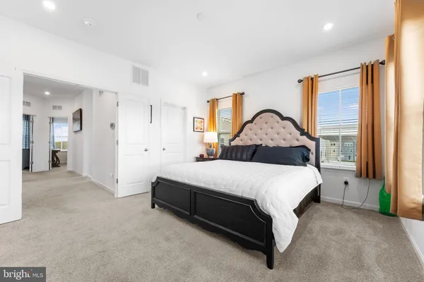 a spacious bedroom with a bed and a mirror