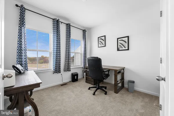 a view of a workspace with furniture and a window