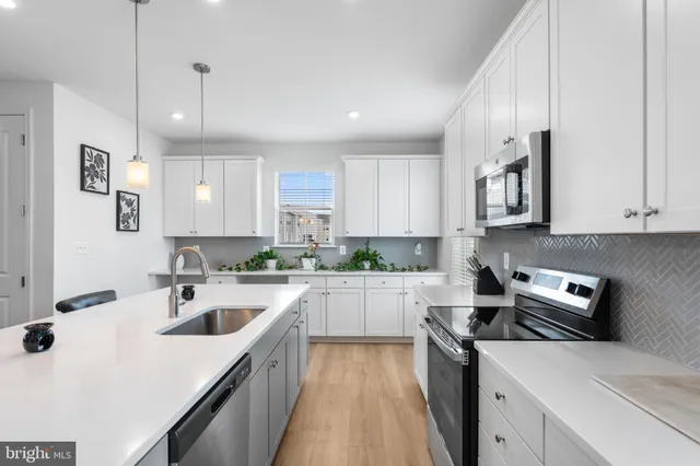 a kitchen with a sink a stove a refrigerator and cabinets