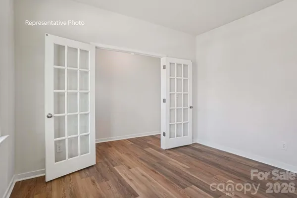 an empty room with wooden floor & cabinet and window
