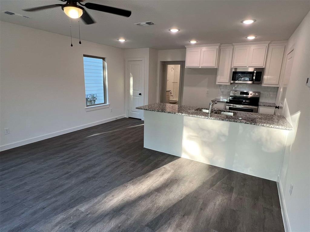 2526 South Fannin Avenue Denison, TX 75020 - Photo 3 of 20 a kitchen with stainless steel appliances granite countertop a sink a stove top oven a counter space and cabinets