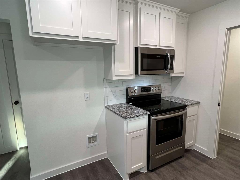 2526 South Fannin Avenue Denison, TX 75020 - Photo 7 of 20 a kitchen with stainless steel appliances granite countertop a stove a microwave and a white cabinets