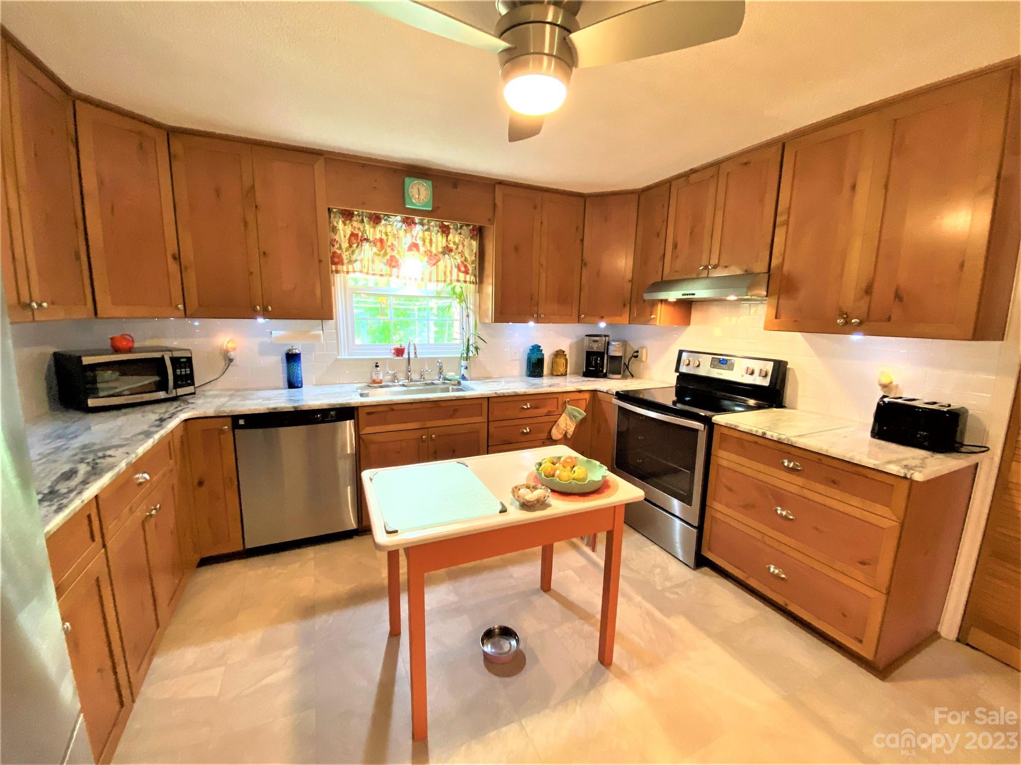 1203 Zeb Helms Road Monroe, NC 28112 - Photo 11 of 46 a kitchen with a sink a stove cabinets and a window
