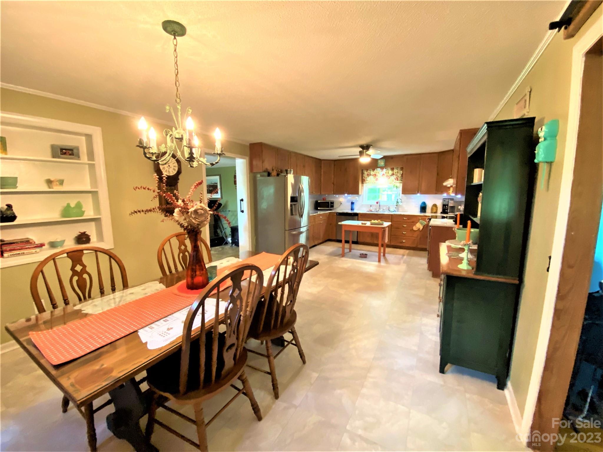 1203 Zeb Helms Road Monroe, NC 28112 - Photo 16 of 46 a view of a dining room with furniture and chandelier