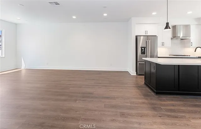 an empty room with wooden floor and window