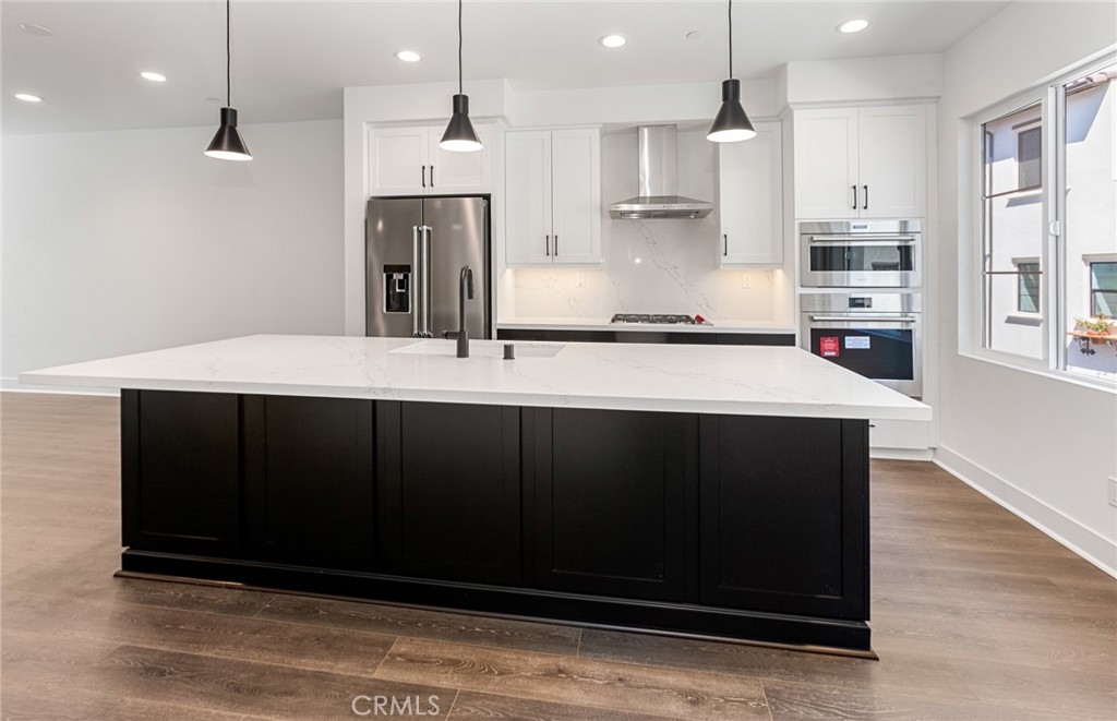 150 Bridle Drive Burbank, CA 91506 - Photo 22 of 36 a kitchen with stainless steel appliances kitchen island granite countertop a refrigerator a stove and a wooden floors