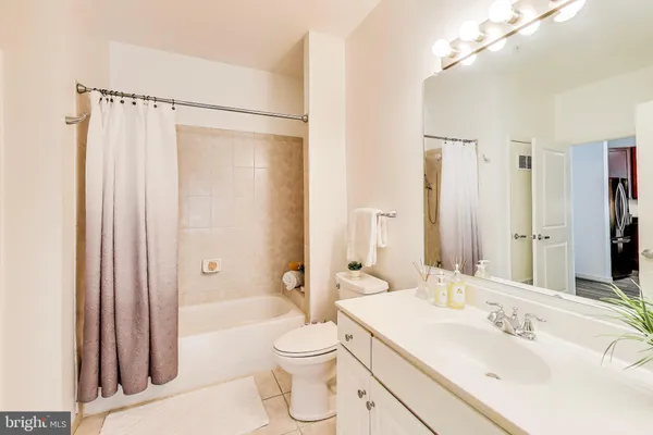 a bathroom with a sink a toilet a mirror and shower