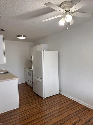 a view of a kitchen with a ceiling fan a refrigerator and a stove top oven