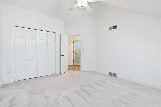 an empty room with a ceiling fan and a window