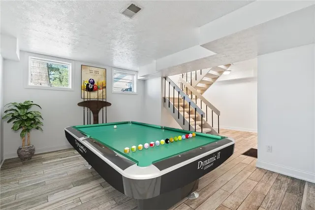 a room with pool table and windows