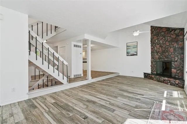 a view of a livingroom with wooden floor and stairs