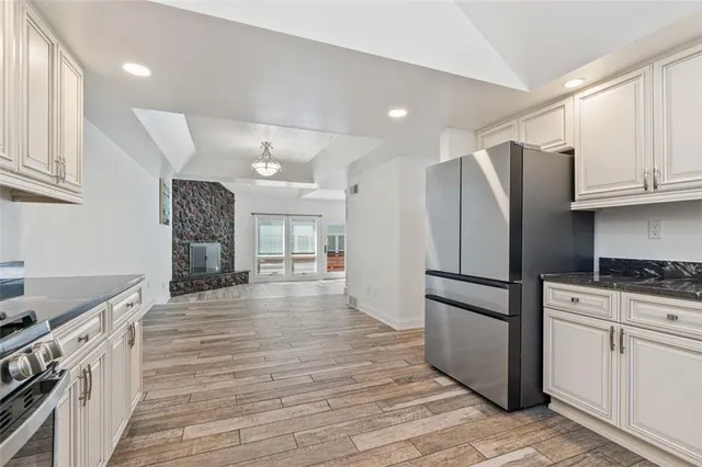 a kitchen with granite countertop a refrigerator and a stove top oven
