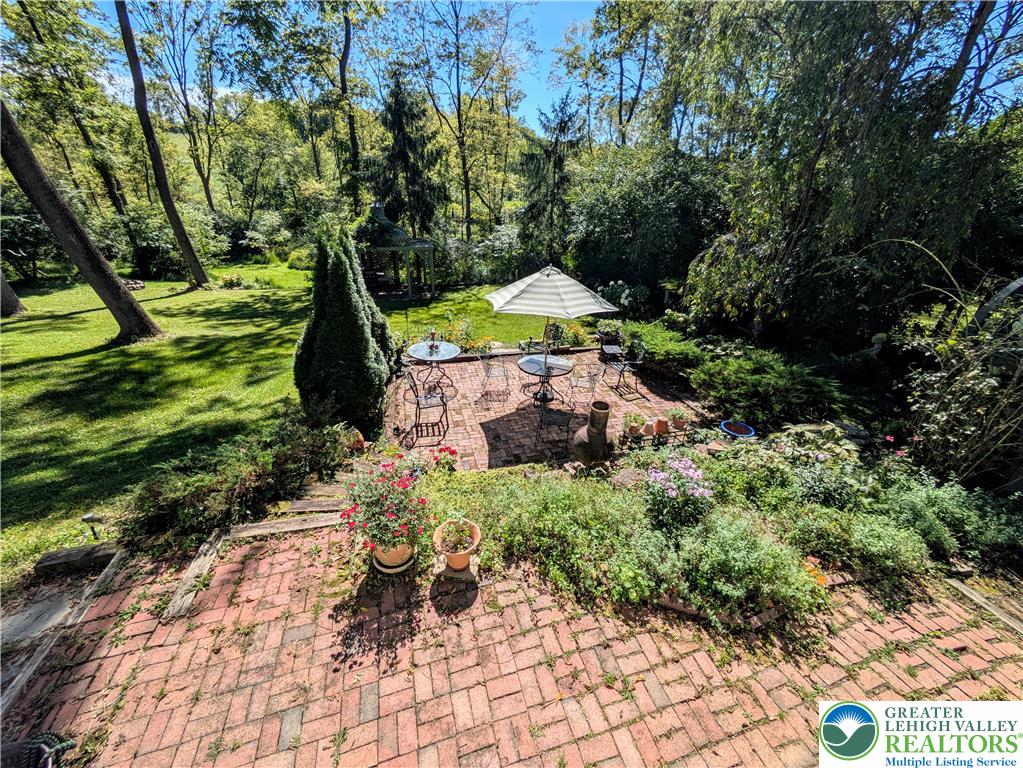 1731 Howell Road Easton, PA 18040 - Photo 45 of 60 Lush mature trees surround a multi-level brick patio designed for outdoor dining and relaxation.