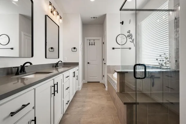 a spacious bathroom with double vanity and mirrors