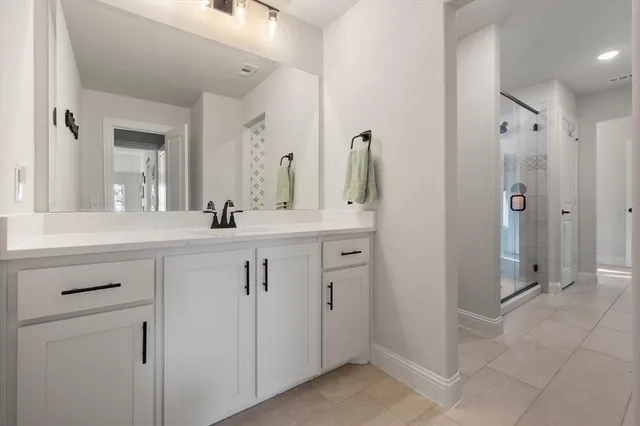 a bathroom with a double vanity sink mirror and shower