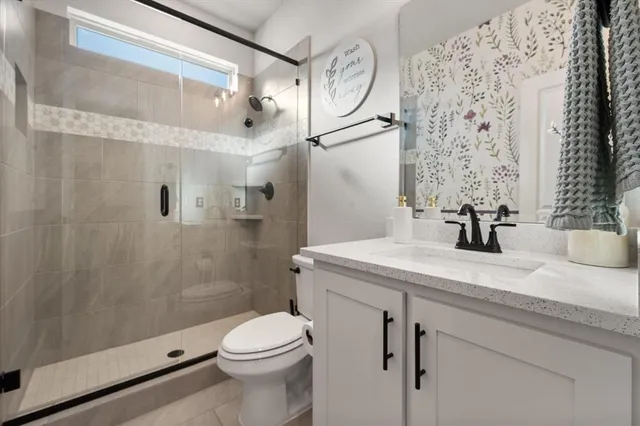 a bathroom with a granite countertop sink toilet and shower