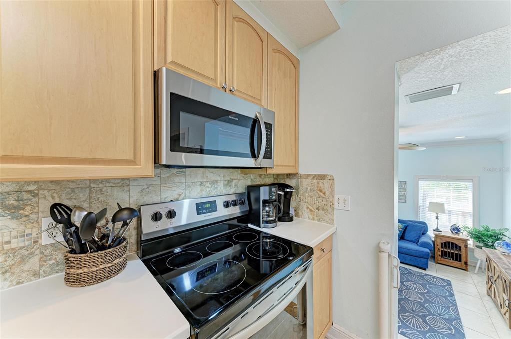 4003 5th Avenue Holmes Beach, FL 34217 - Photo 18 of 56 a kitchen with stainless steel appliances a stove a microwave sink and cabinets