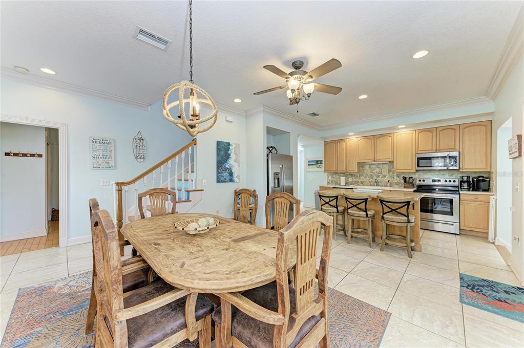 4003 5th Avenue Holmes Beach, FL 34217 - Photo 22 of 56 a view of a dining room and livingroom with furniture a rug a chandelier and kitchen view