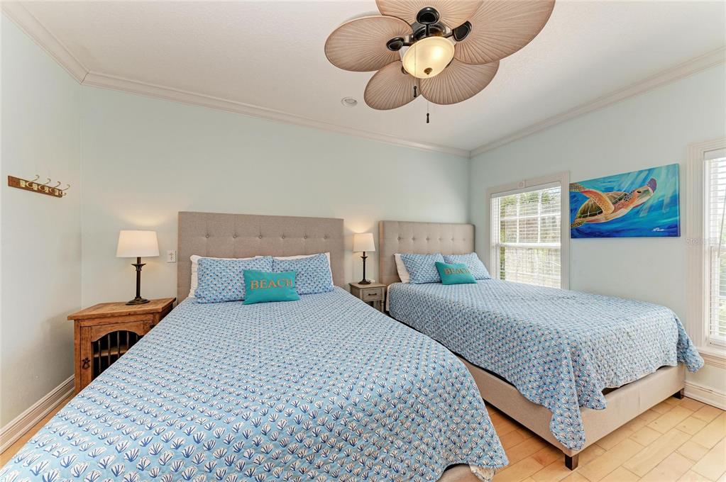 4003 5th Avenue Holmes Beach, FL 34217 - Photo 38 of 56 a bedroom with a large bed and a chandelier