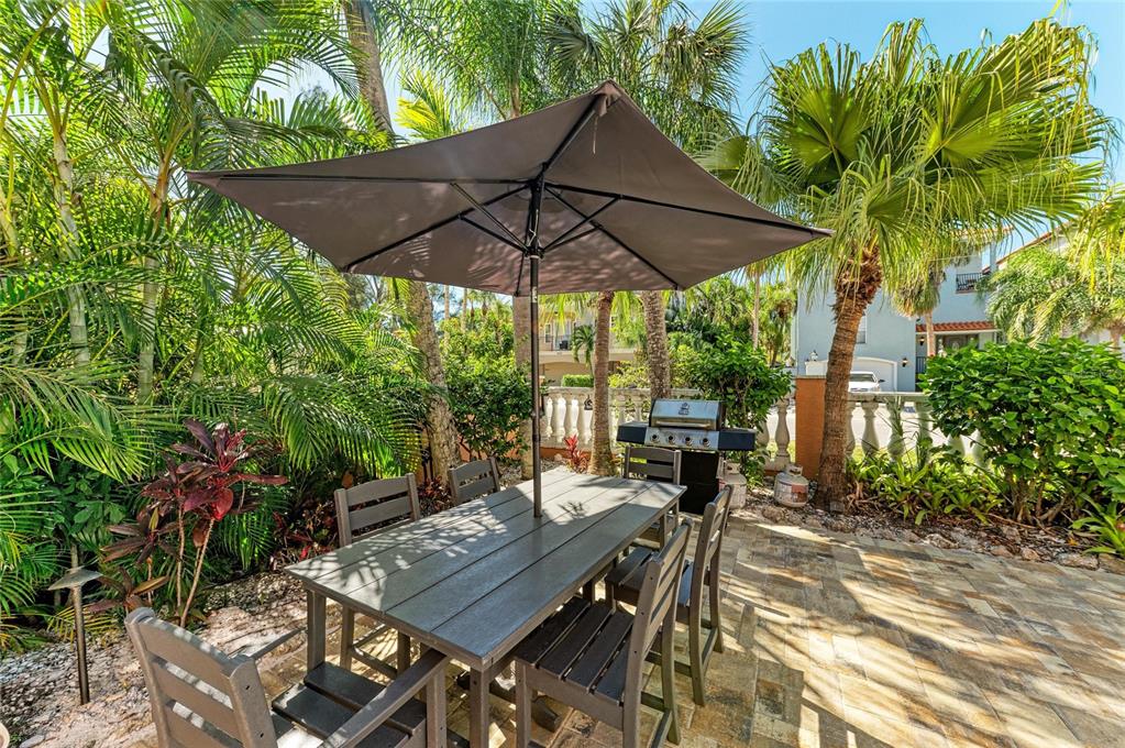 4003 5th Avenue Holmes Beach, FL 34217 - Photo 49 of 56 a view of a patio with table and chairs under an umbrella