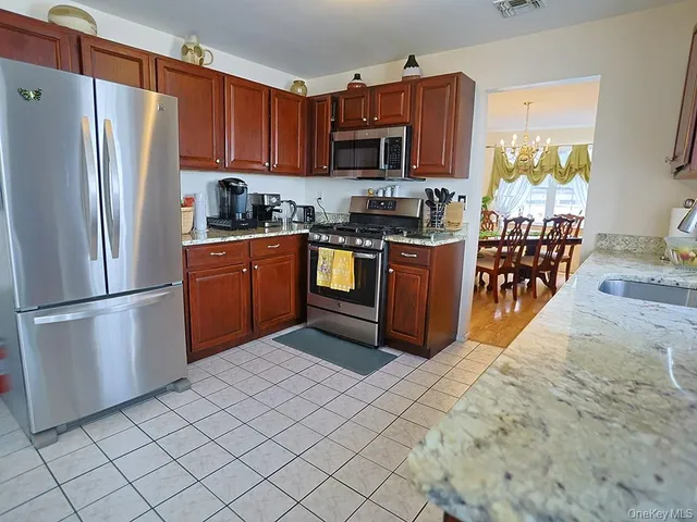 a kitchen with stainless steel appliances granite countertop a refrigerator stove and a sink