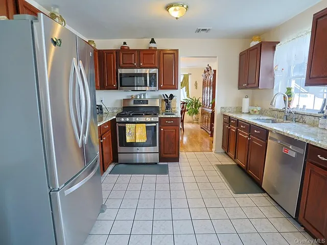 a kitchen with stainless steel appliances granite countertop a refrigerator stove and sink