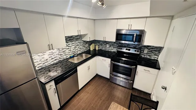 a kitchen with stainless steel appliances granite countertop a stove and a refrigerator
