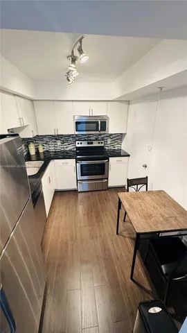 a living room with stainless steel appliances kitchen island granite countertop lots of wooden furniture