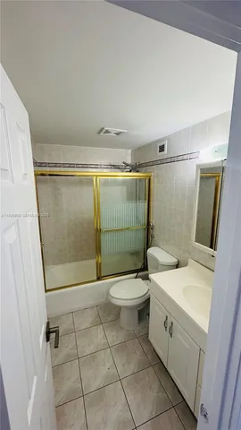 a bathroom with a toilet a sink a shower and mirror