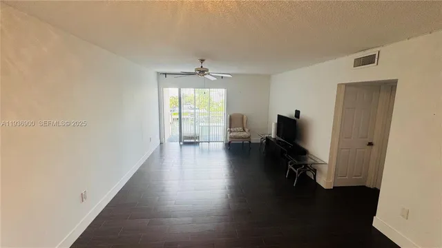 a view of a hallway with wooden floor and lounge chair