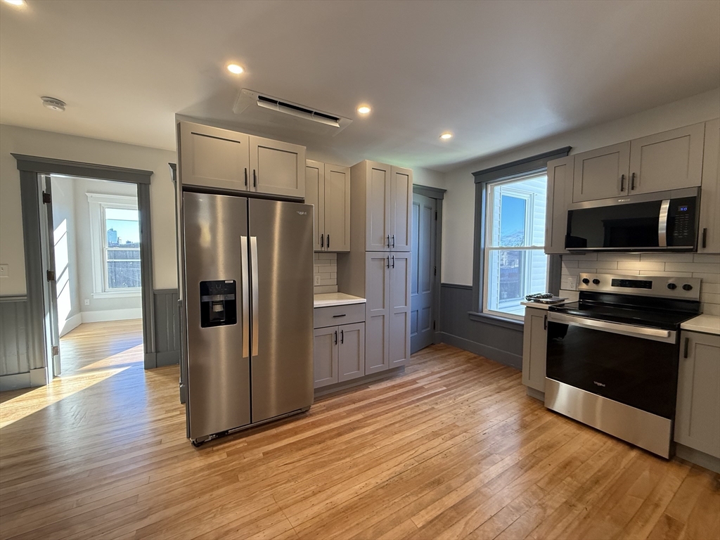 237 Park Avenue, Unit 3 Worcester, MA 01609 - Photo 5 of 20 a kitchen with stainless steel appliances a refrigerator and a stove top oven