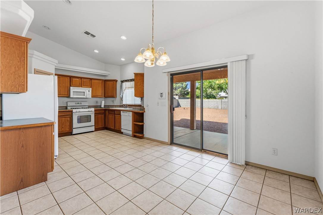 3973 Prairie View Drive Kingman, AZ 86409 - Photo 14 of 34 The kitchen and dining area features tile flooring, wood cabinetry, and white appliances