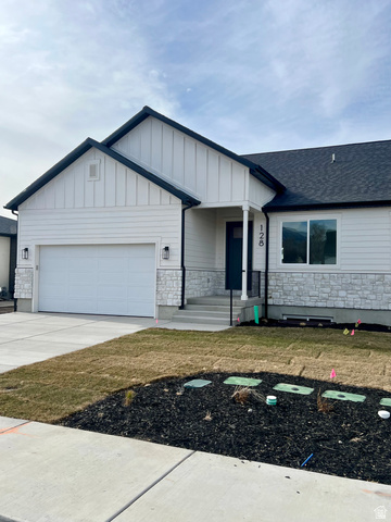 128 South 300 West Payson, UT 84651 - Photo 1 of 1 View of front of property featuring stone siding, concrete driveway, a garage, board and batten siding, and a front lawn