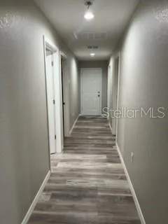 a view of a hallway with wooden floor and closet
