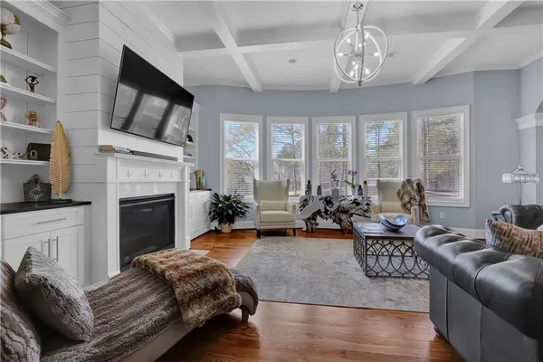 a living room with furniture fireplace and a large window