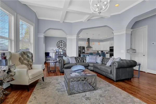 a living room with furniture a large window and a chandelier