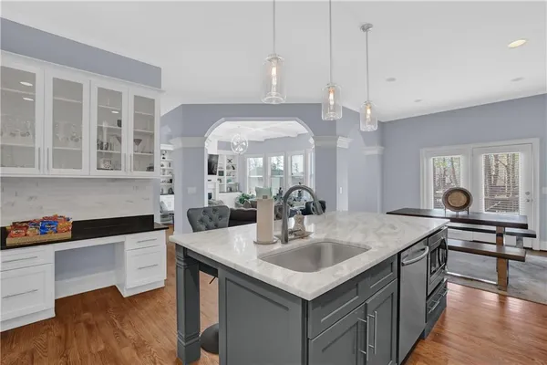 a kitchen with a sink a counter space appliances and cabinets