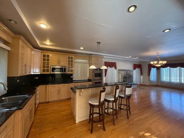 a kitchen with stainless steel appliances a dining table chairs and wooden floor
