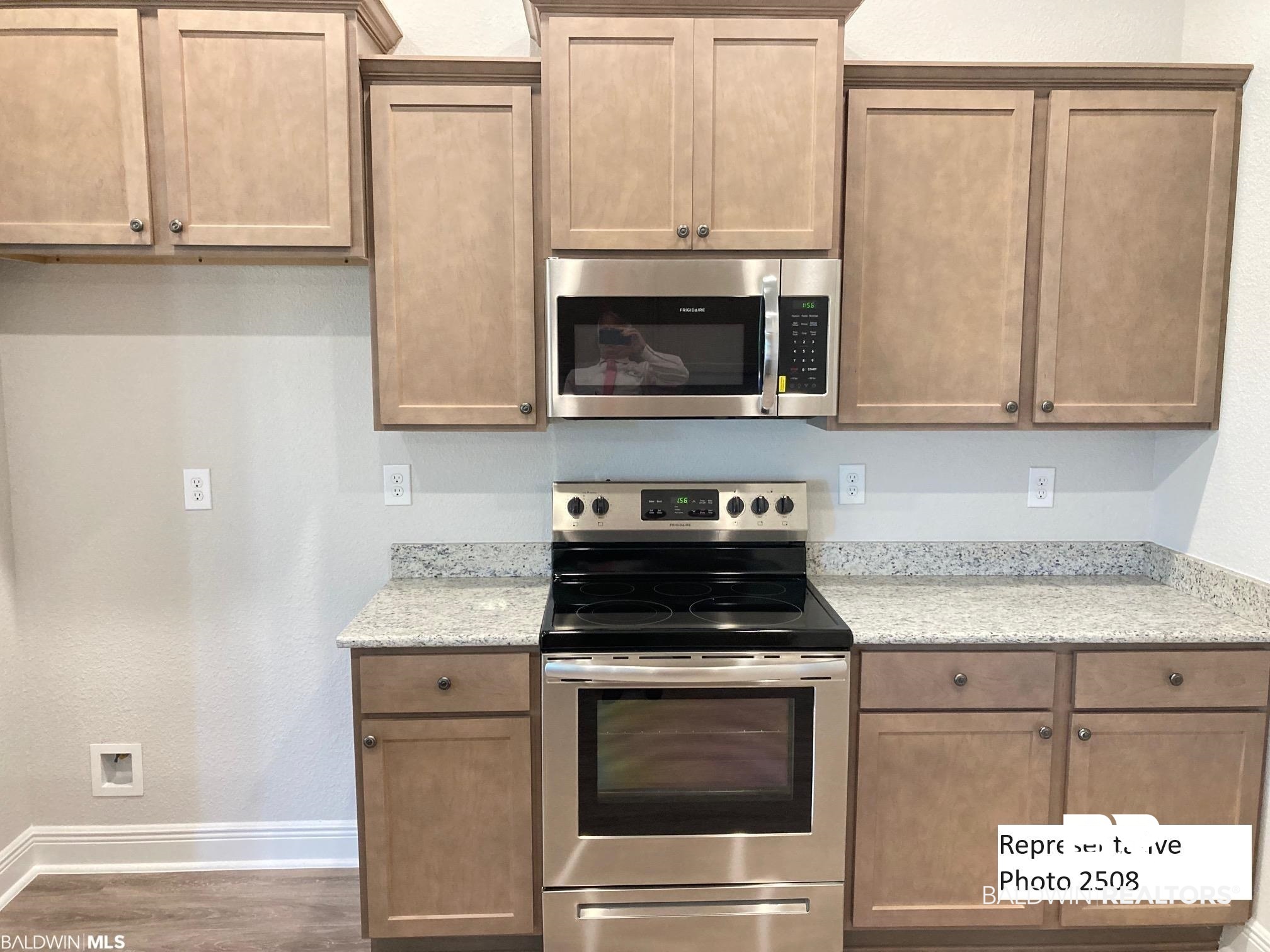 2201 Pollard Road Daphne, AL 36526 - Photo 5 of 15 Kitchen featuring dark wood-type flooring, stainless steel appliances, and light stone counters