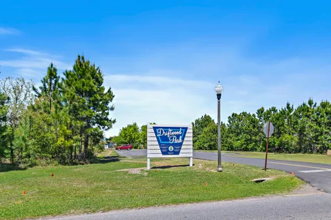 a swimming pool with lots of green space and trees in the background