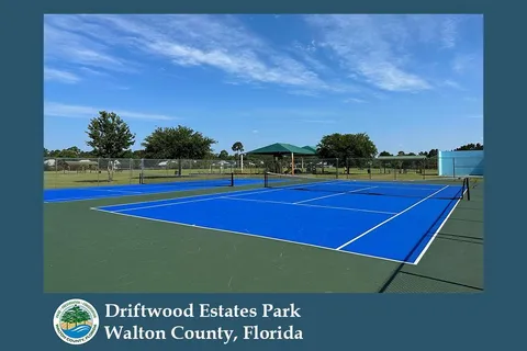 a view of tennis court with seating area