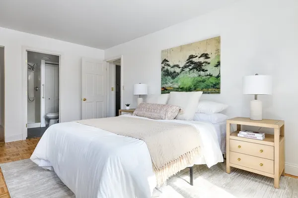 a bedroom with a bed and a painting on the wall