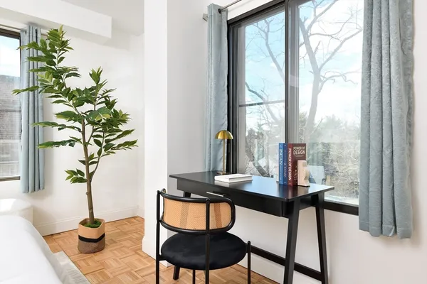 a dining room with furniture and a potted plant