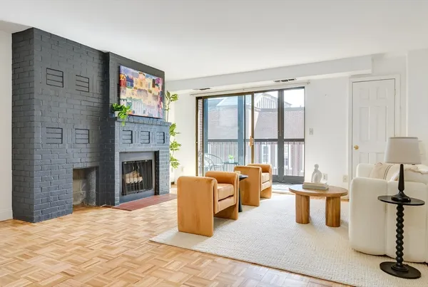 a living room with furniture large window and a fireplace