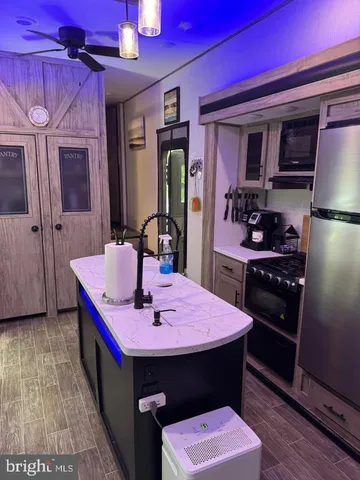 a kitchen with a sink refrigerator and cabinets