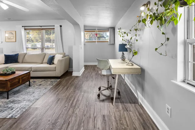 a view of an empty room with a window and wooden floor