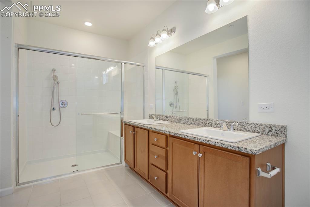 3865 Presidio Point, Unit 101 Colorado Springs, CO 80920 - Photo 12 of 20 a bathroom with a granite countertop sink mirror and shower