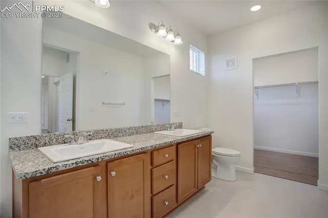 a bathroom with a granite countertop sink a toilet and a mirror
